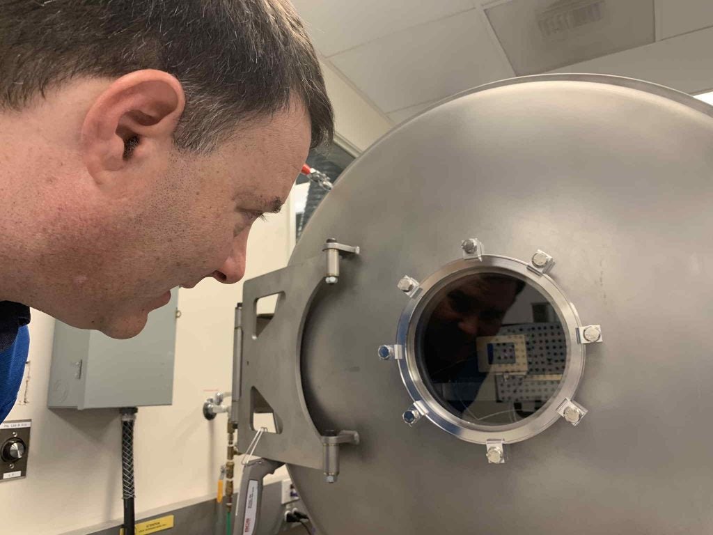 Mastcam-Z P.I. Jim Bell admires the view of one of the flight cameras being tested inside a thermal vacuum chamber at Malin Space Science Systems in April, 2019.