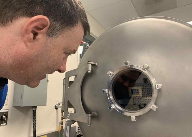 Mastcam-Z P.I. Jim Bell admires the view of one of the flight cameras being tested inside a thermal vacuum chamber at Malin Space Science Systems in April, 2019.